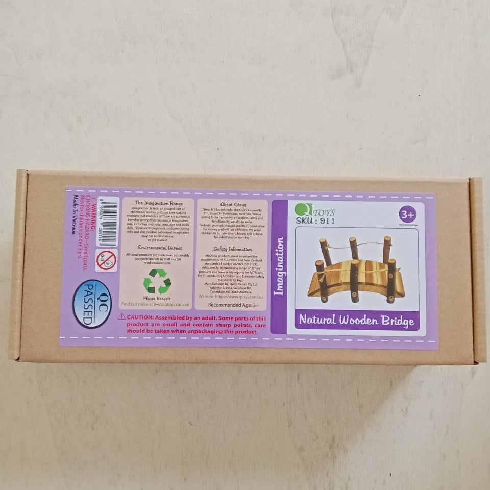 Cardboard box with a wooden bridge toy on a light gray background