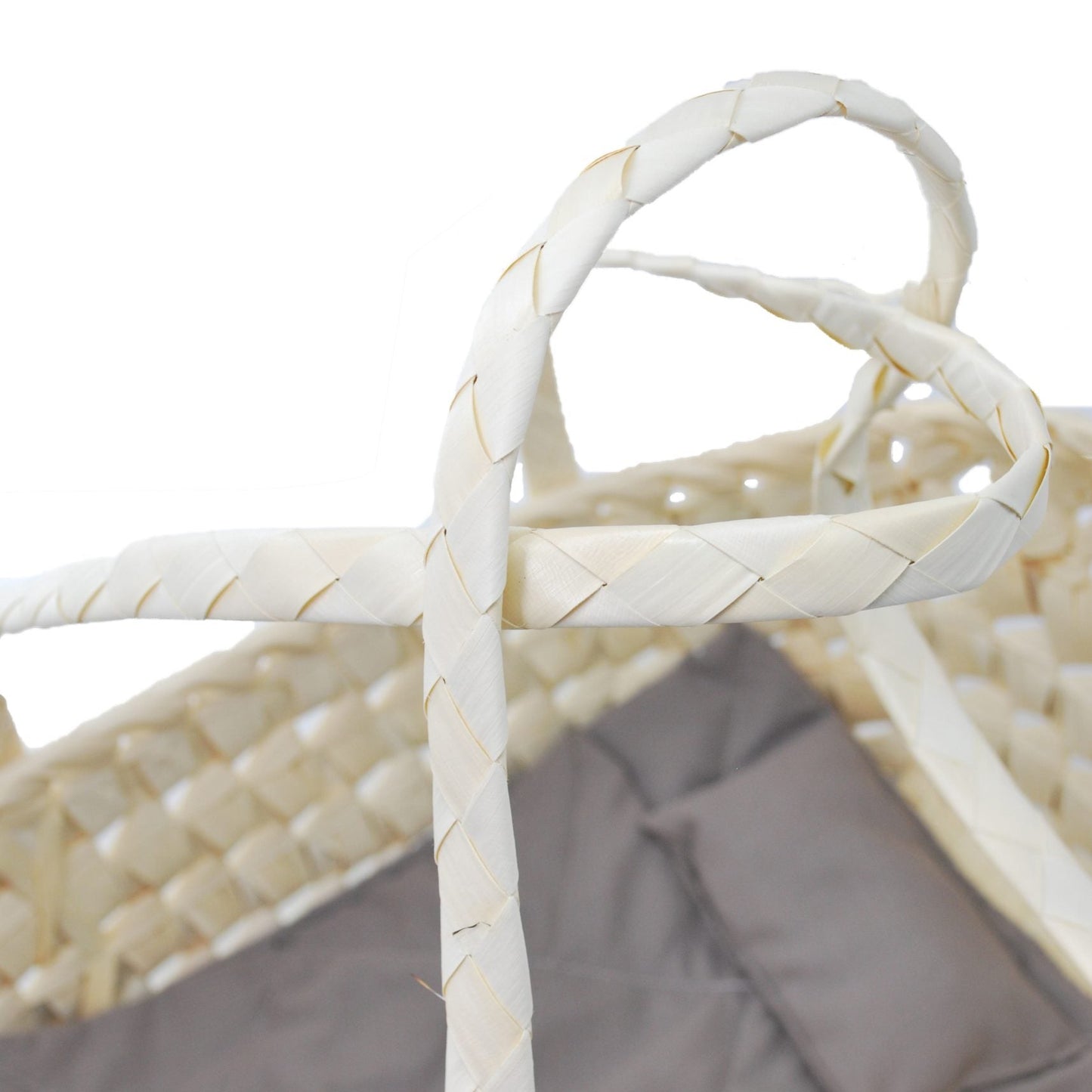 Wicker baby crib with gray cushion on a white background