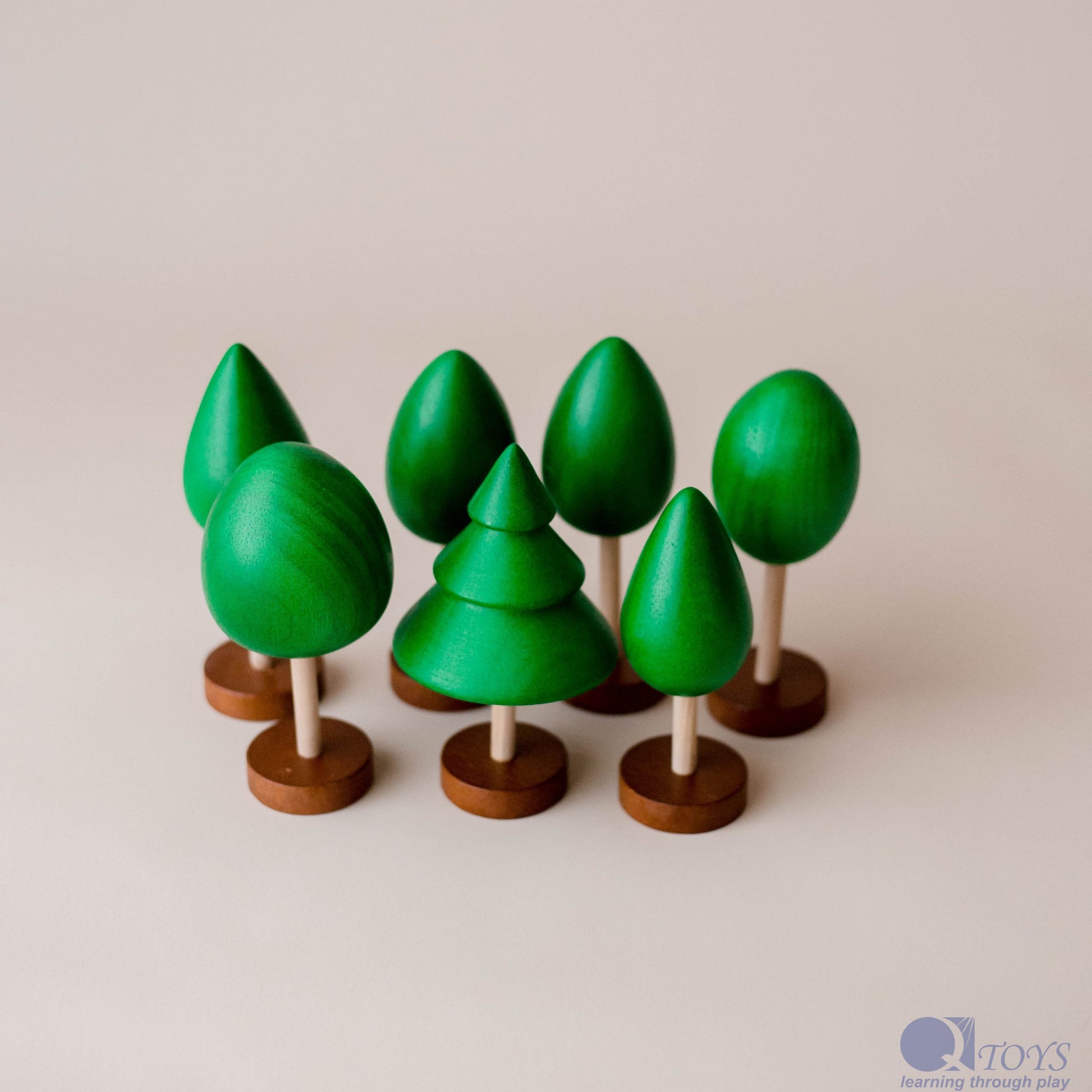Set of green wooden trees on a beige background